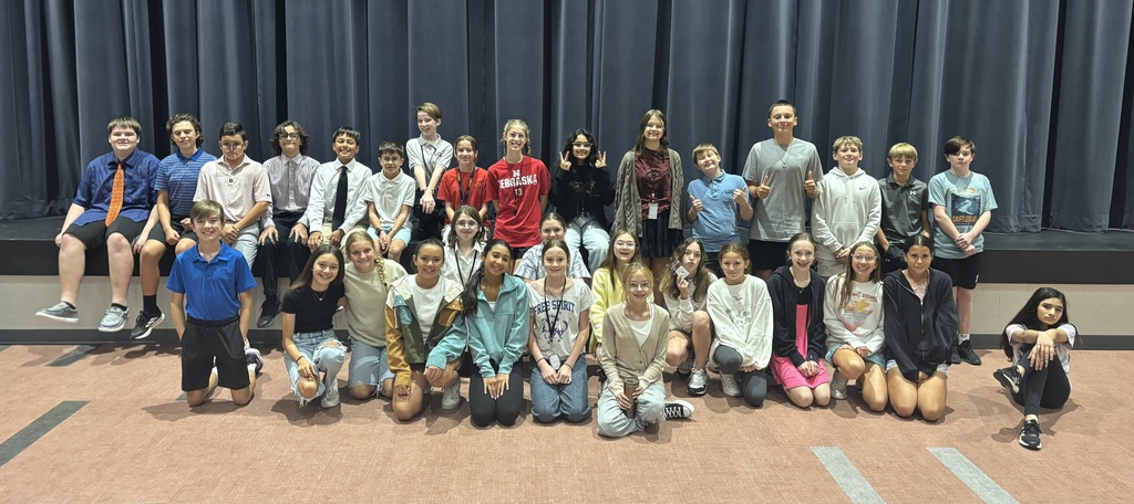7th grade students who dressed up for sprit week, posing in front of the stage in the cafeteria. 