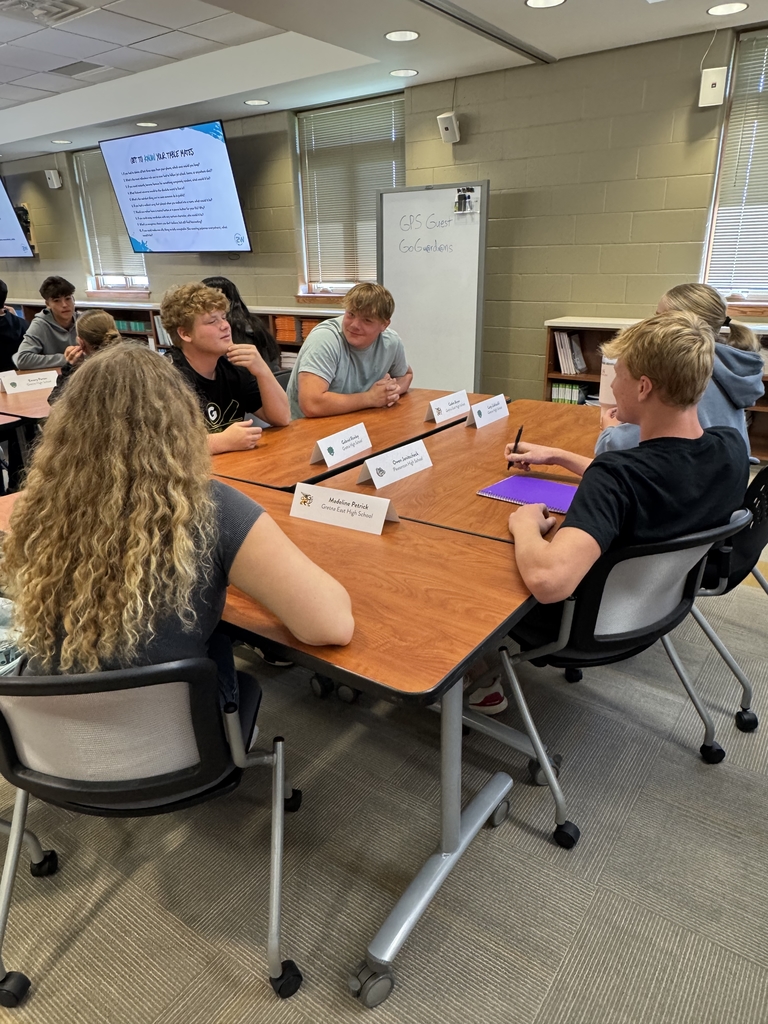 group of high school students sitting at tables getting to know each other 