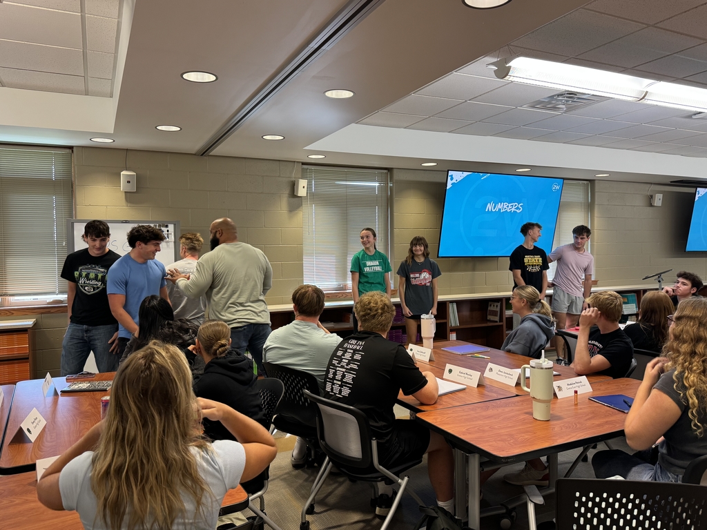 Groups of students standing in front of conference room playing numbers game while Steve Mackey gives them instructions