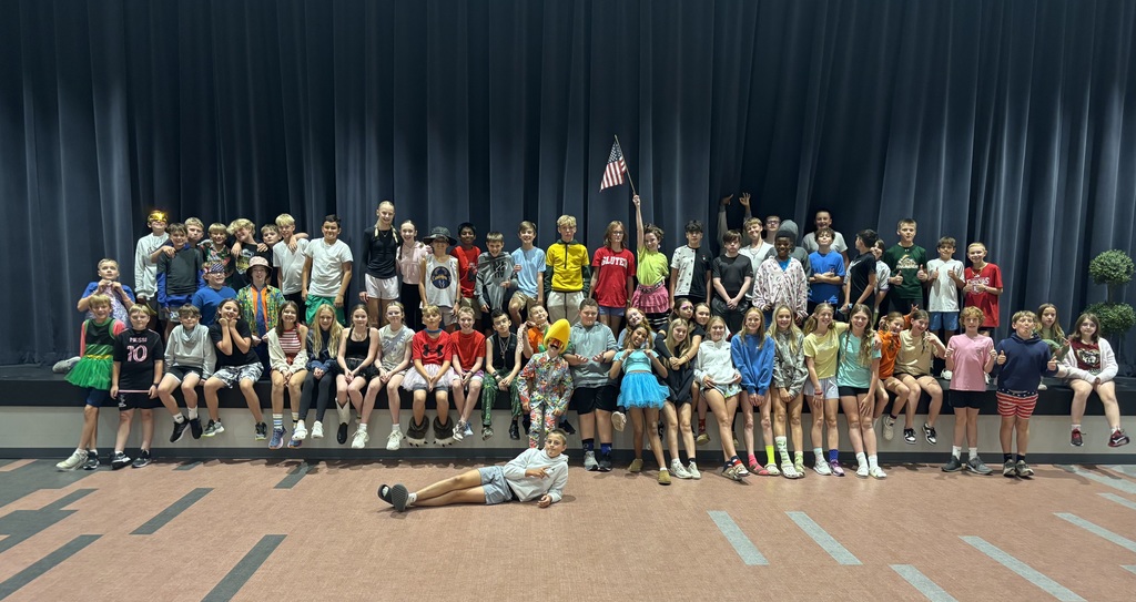 7th grade students who dressed up for sprit week, posing in front of the stage in the cafeteria. 