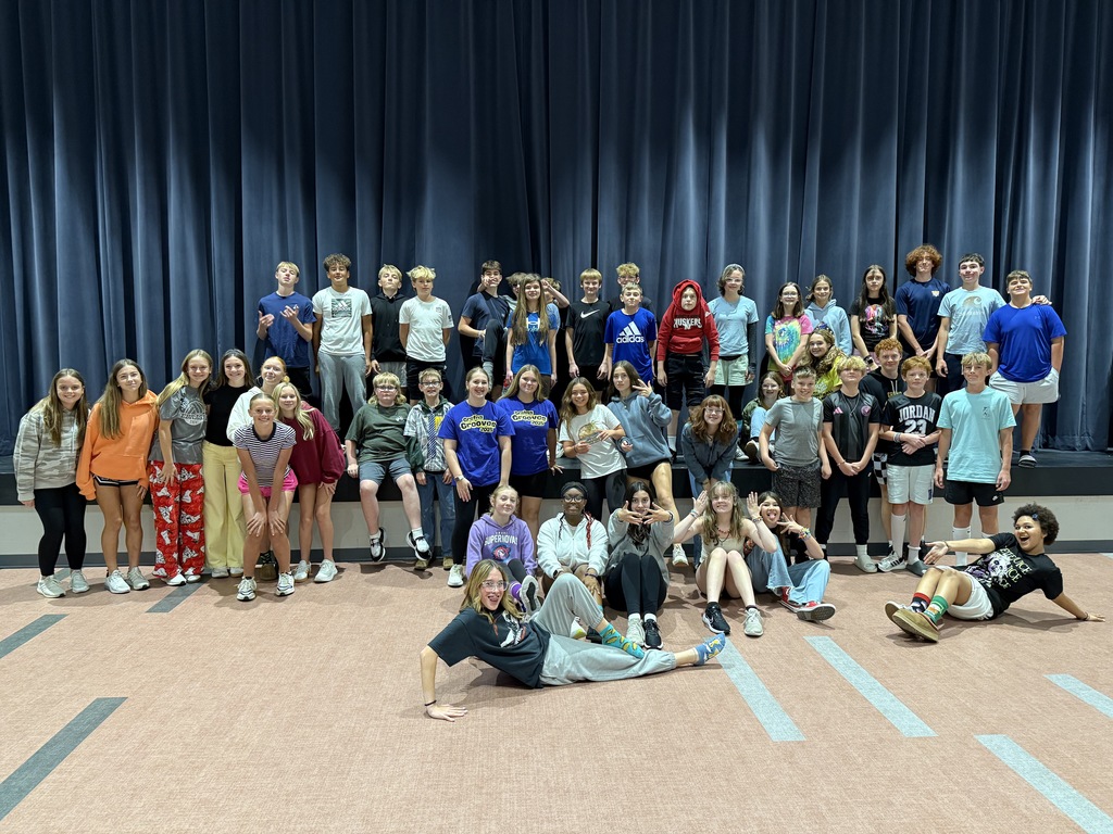 8th grade students who dressed up for sprit week, posing in front of the stage in the cafeteria. 