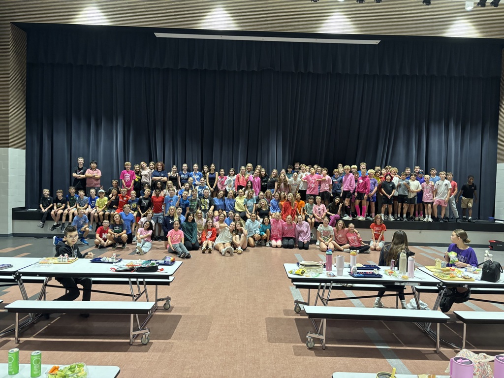 7th grade students who dressed up for sprit week, posing in front of the stage in the cafeteria. 