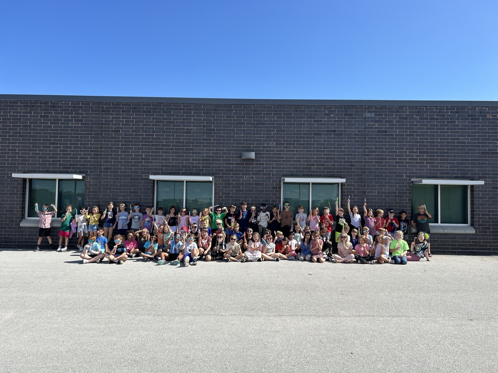 3rd graders outside holding up popsicles and wearing sunglasses.
