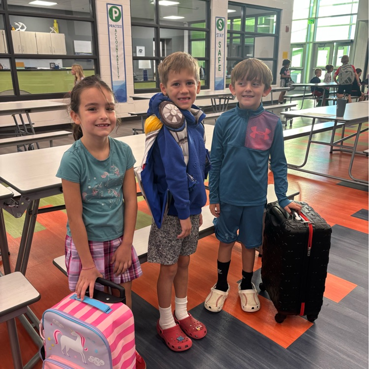 3 students with suitcases for their “backpacks"