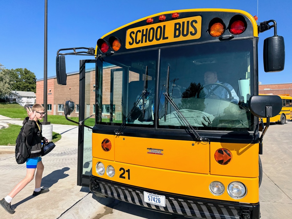 Middle School student waving as he gets on the bus Superintendent Lightle is driving
