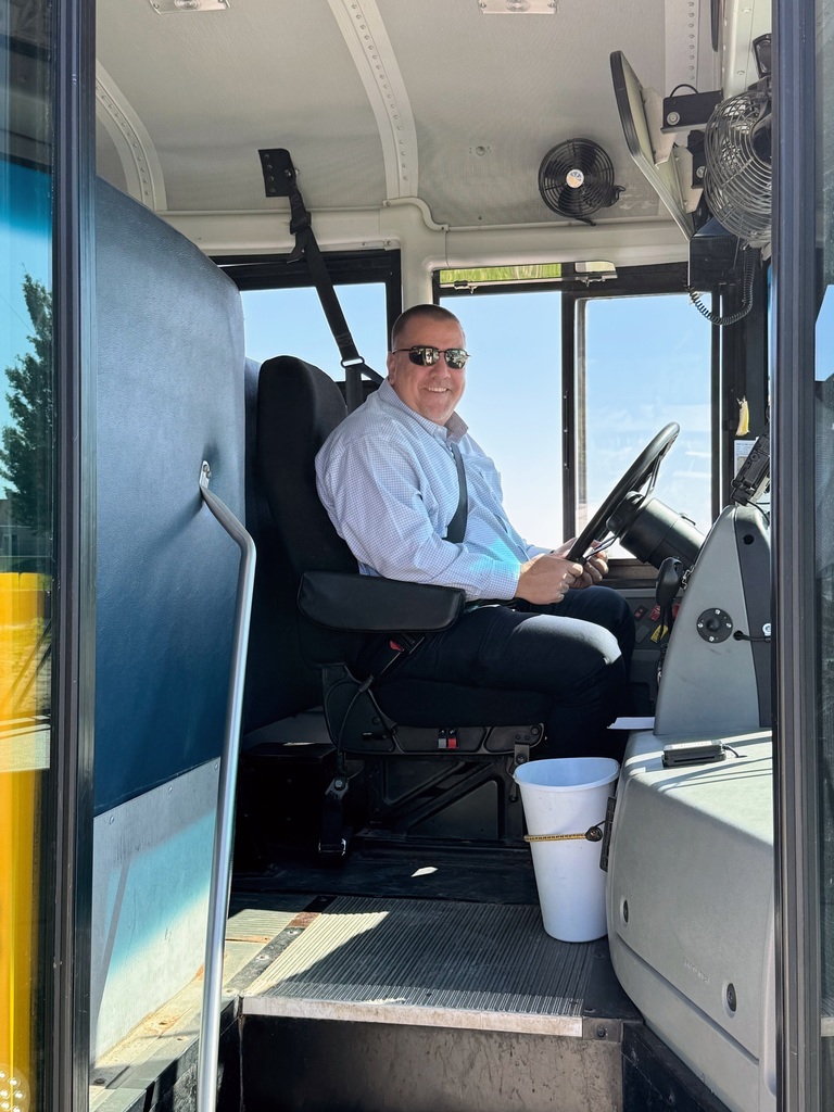 Superintendent Lightle sitting at the driver seat on the bus all smiles waiting for the students to drive them home for the day