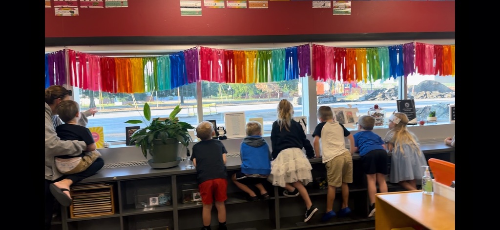 A group of Gretna Elementary school students looking out the windows of the classroom at the construction work being done