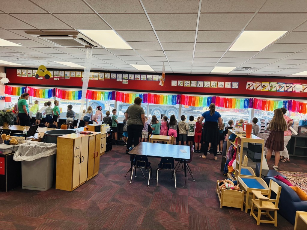 Gretna Elementary school students lined up at the classroom windows with teachers standing behind them all looking out the window at the construction workers