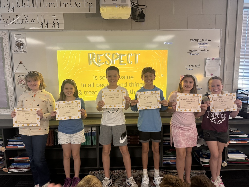 Six students holding certificates standing in front of a whiteboard with the phrase "Respect is seeing value in all people and things and treating them with care".