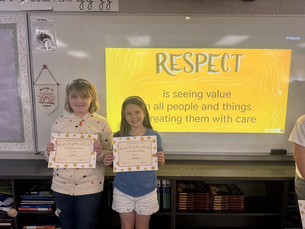 Two girls standing in front of a whiteboard with the phrase "Respect is seeing value in all people and things and treating them with care".