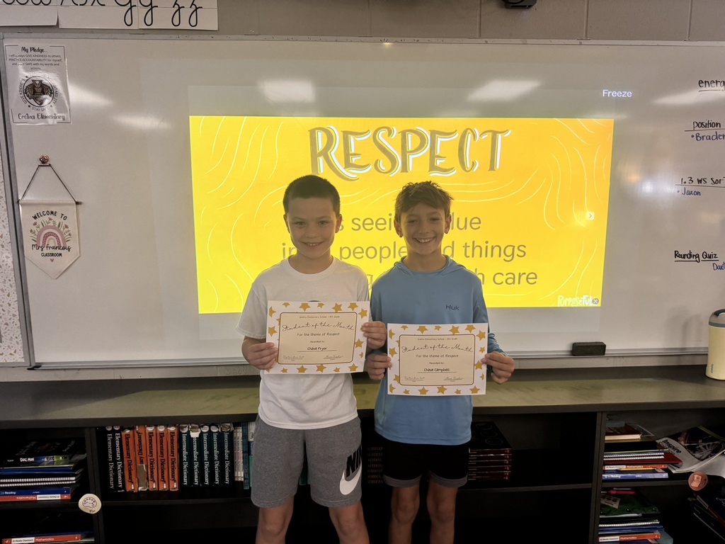 Two boys standing in front of a whiteboard with the phrase "Respect is seeing value in all people and things and treating them with care".