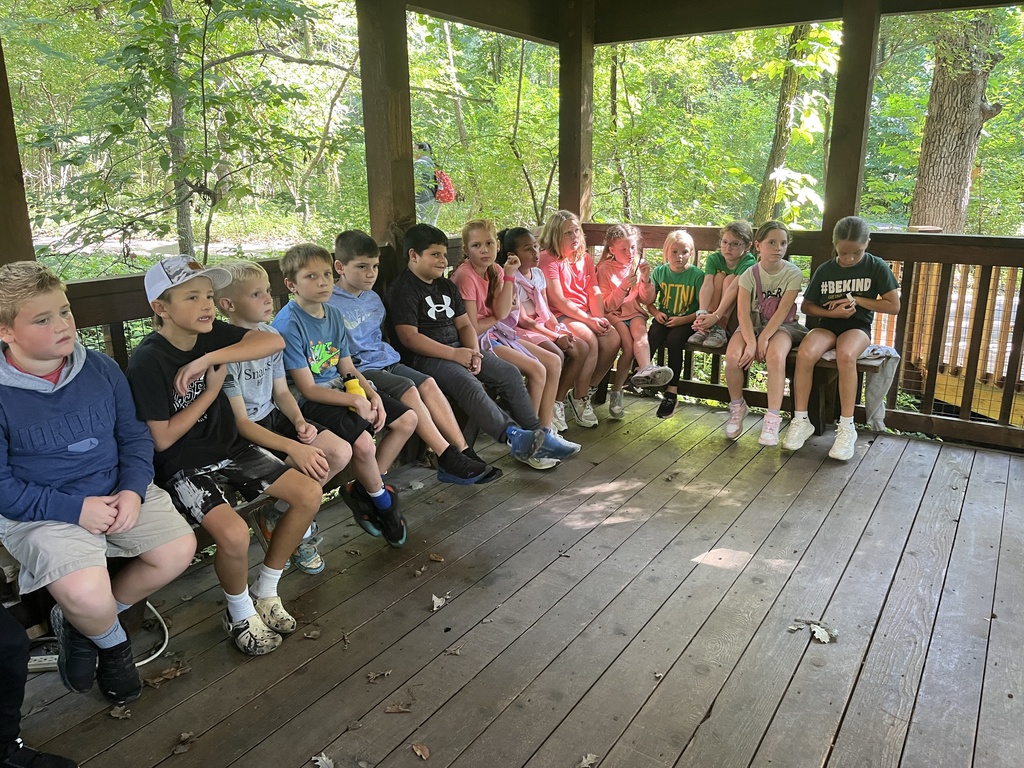 Group of students sitting underneath a covered patio.