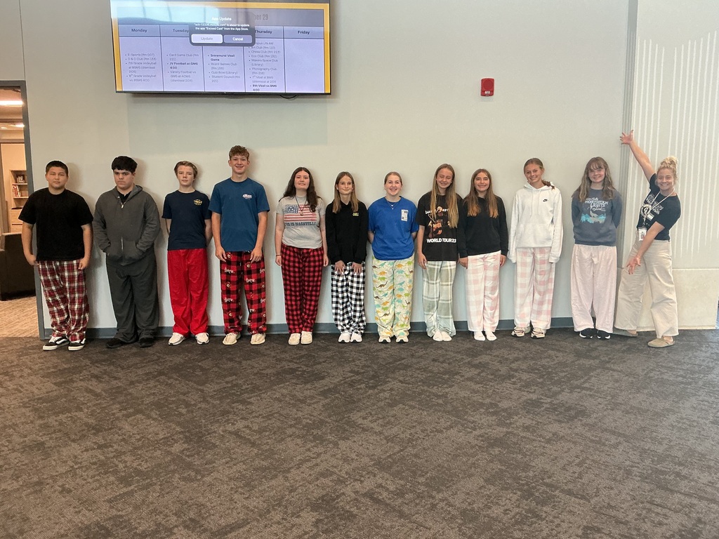 Ms. Weis and 8th grade students modeling their pajama pants in the front hallway.