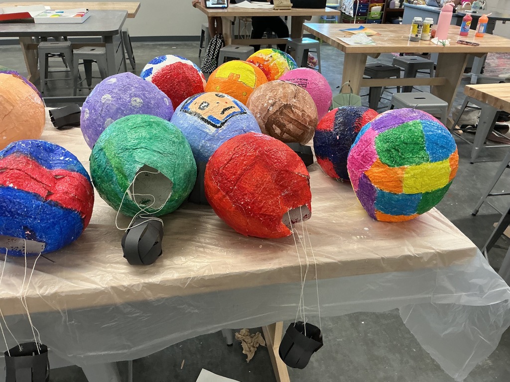 Photo of colorful, student-made hot air balloons sitting on a table.