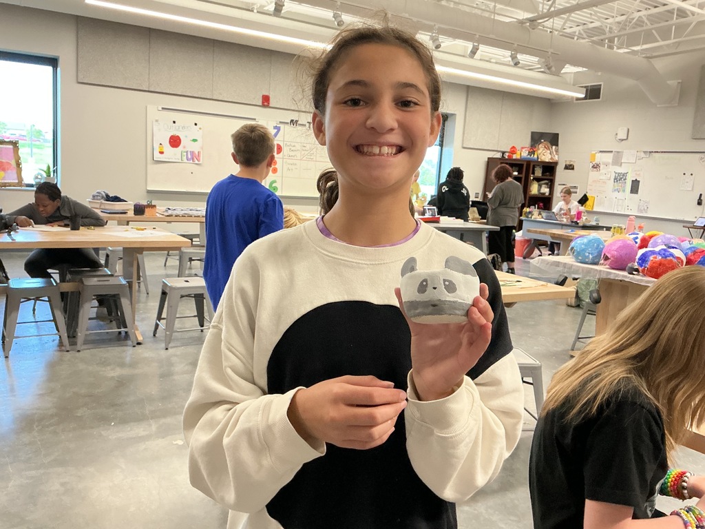 Photo of a student with her clay creation.