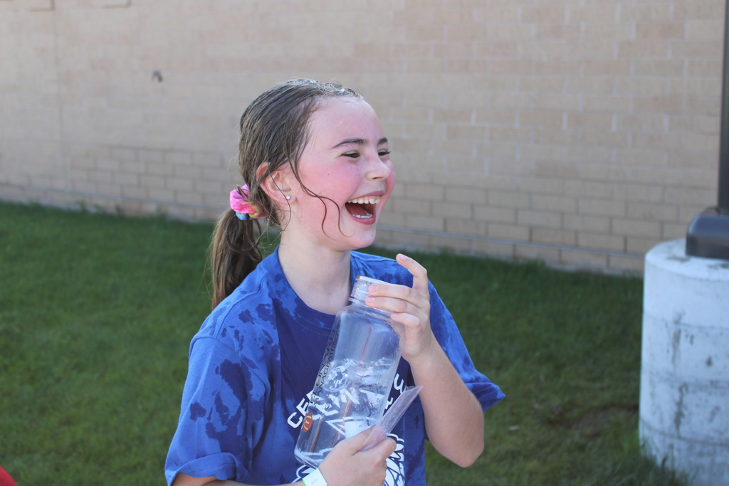 A second grade student cools off with cold water after her race! 