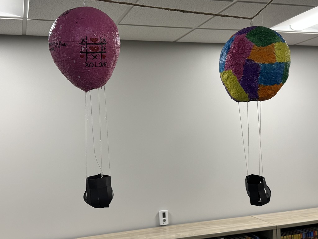 Plaster hot air balloons are strung up in the library.