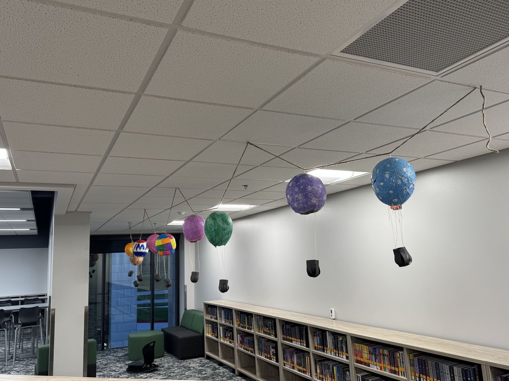 Plaster hot air balloons are strung up in the library.