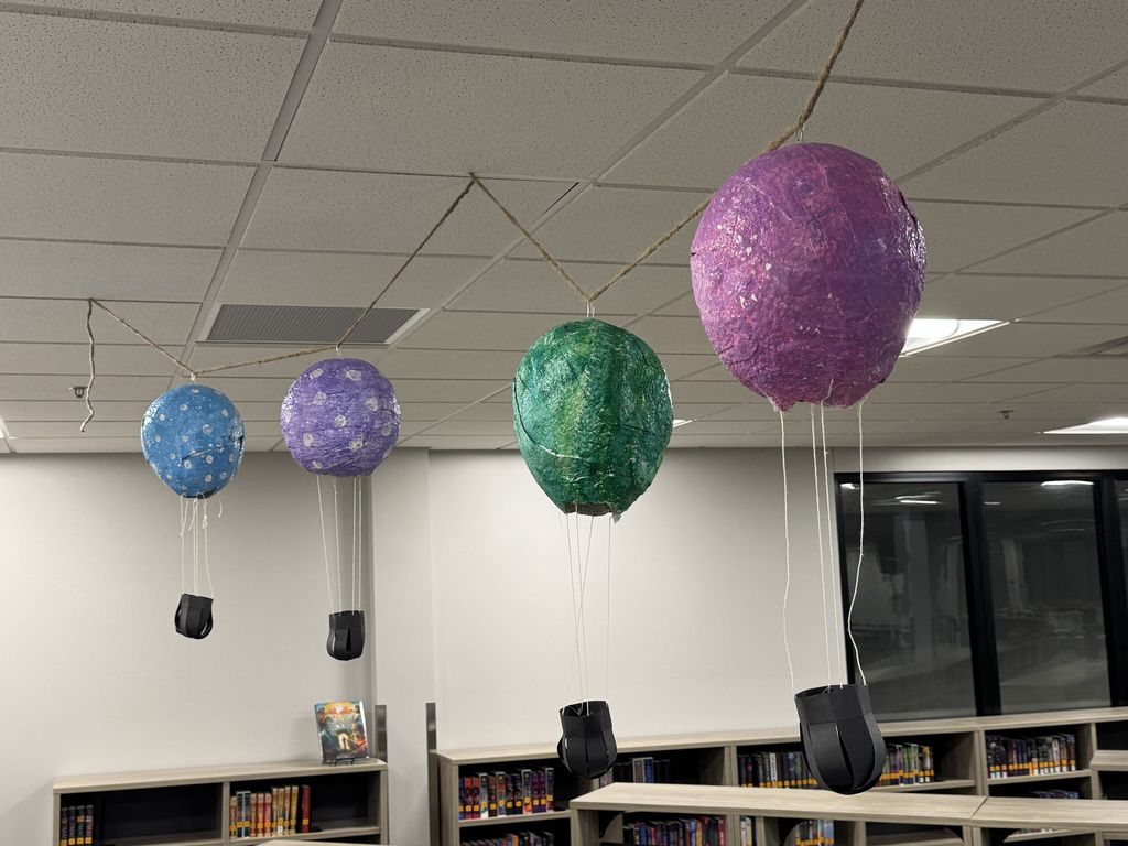 Plaster hot air balloons are strung up in the library.