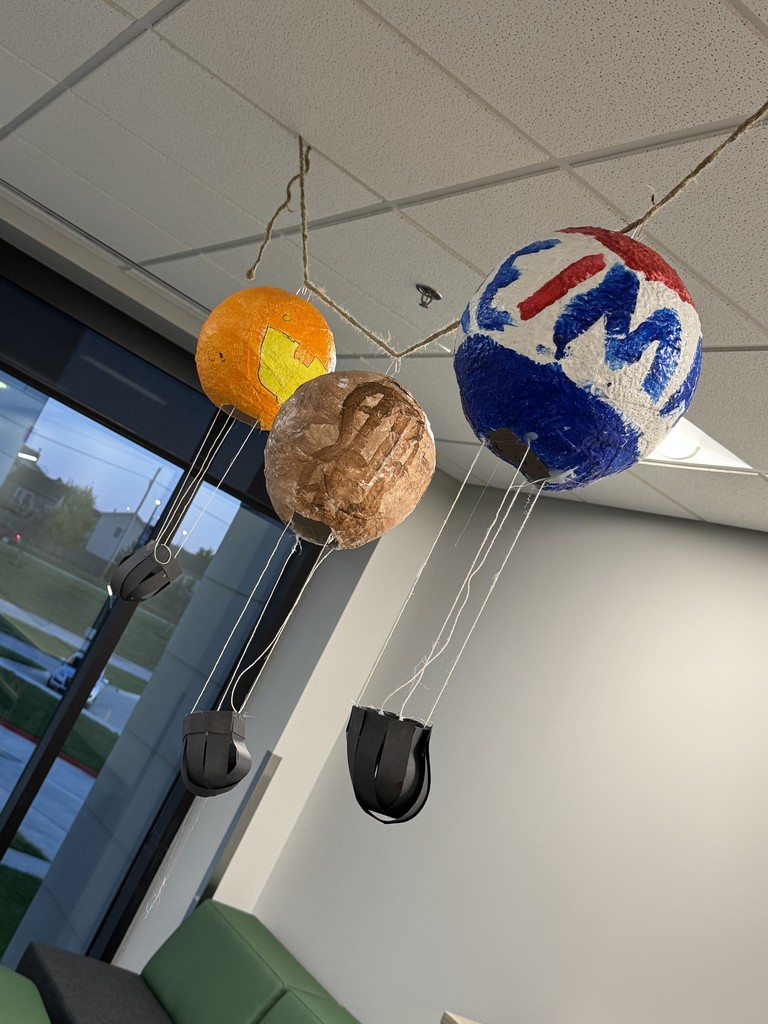 Plaster hot air balloons are strung up in the library.