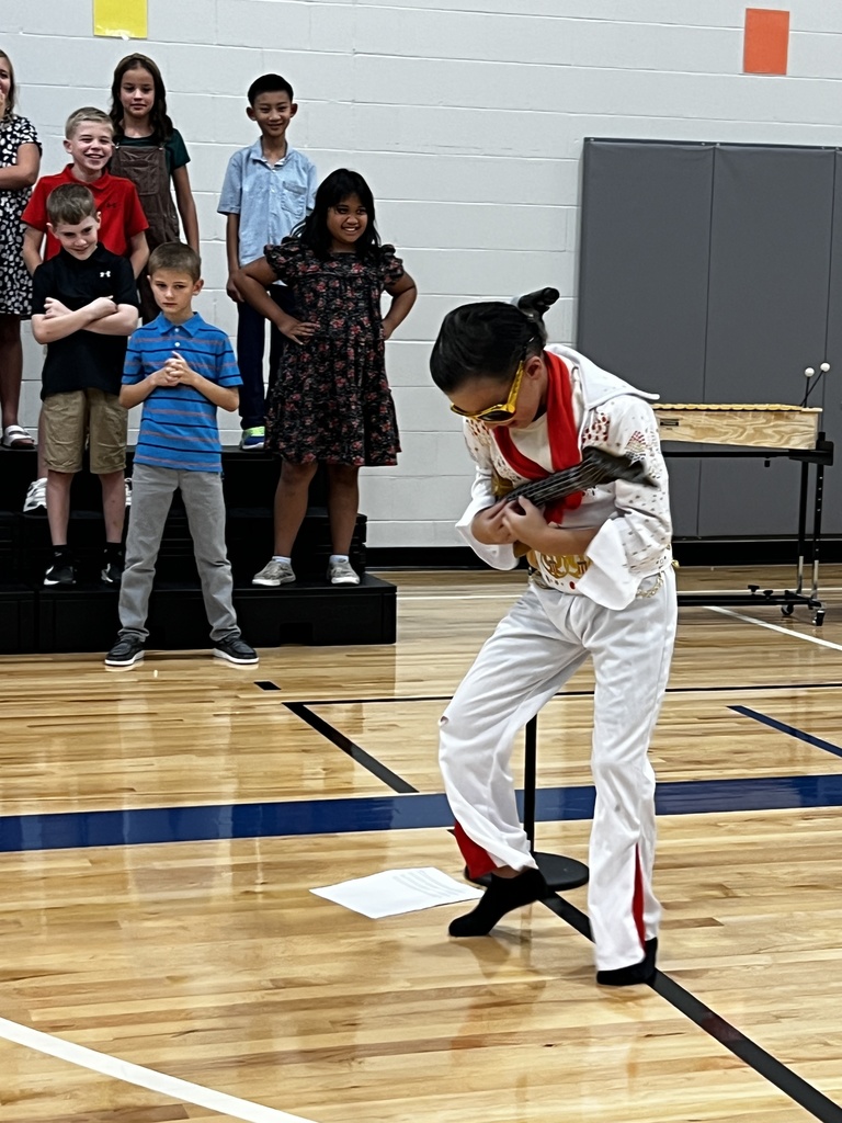 A 3rd grade boy dresses at Elvis Presley for the program.