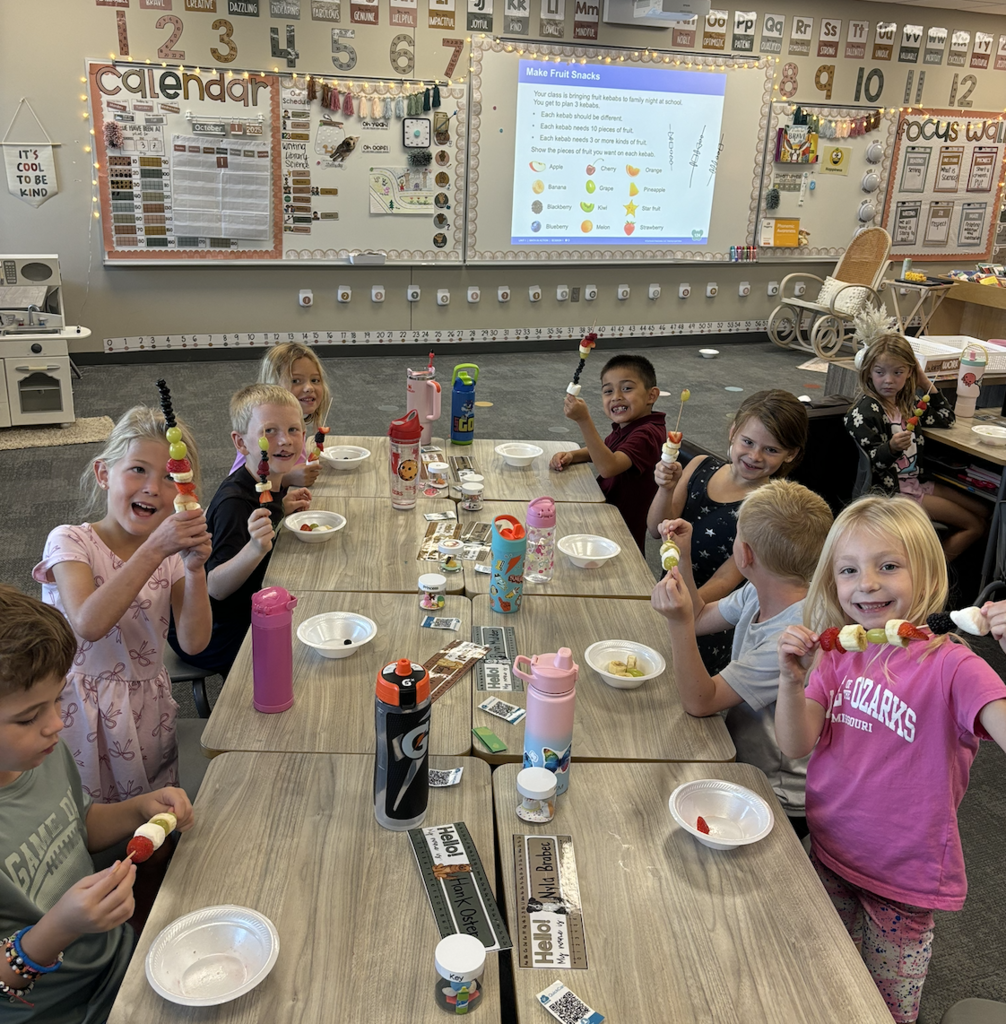 first graders making fruit kebobs