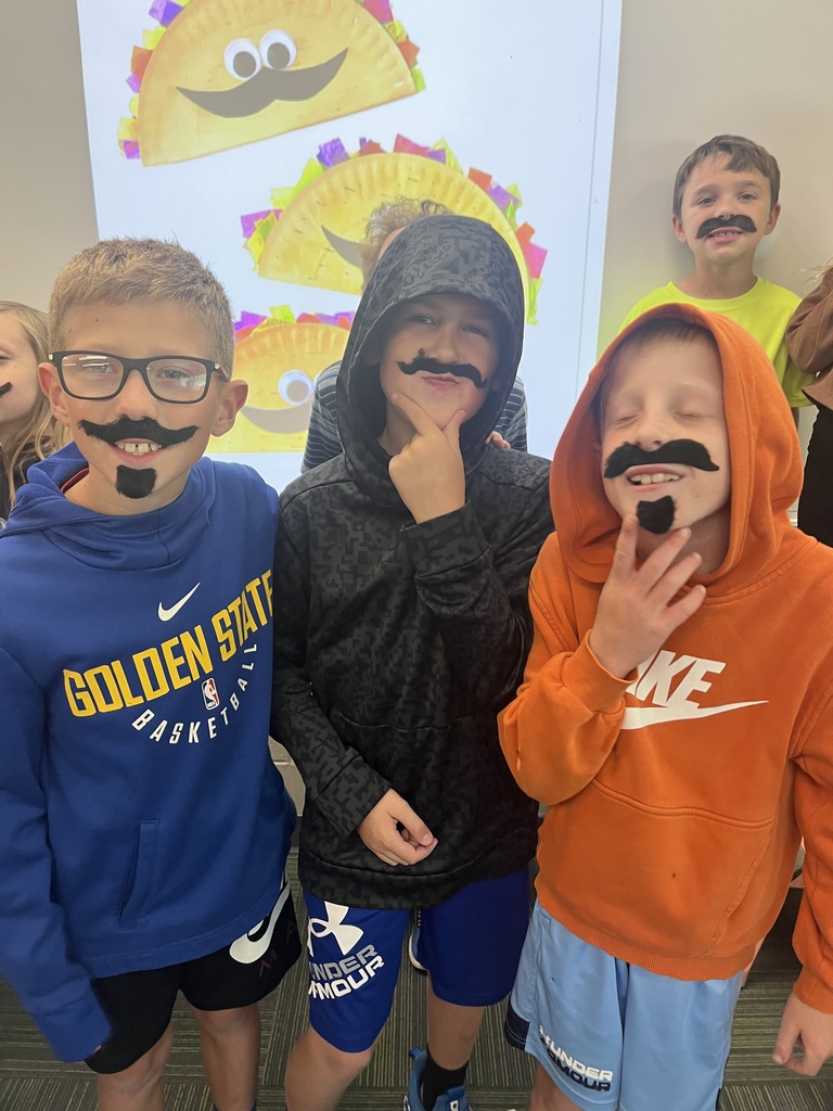 3 boys, all wearing sweatshirts, wearing fake mustaches and beards.