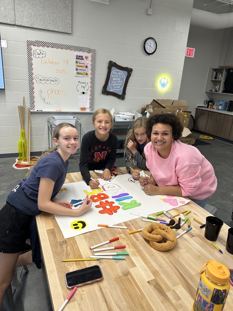 Students in art club working on a poster.