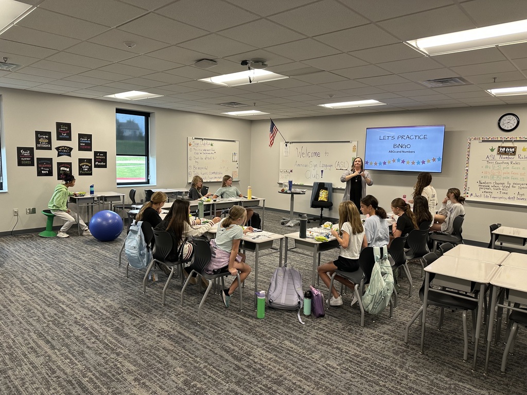 A teacher presenting American Sign Language Bingo to a group of students. 