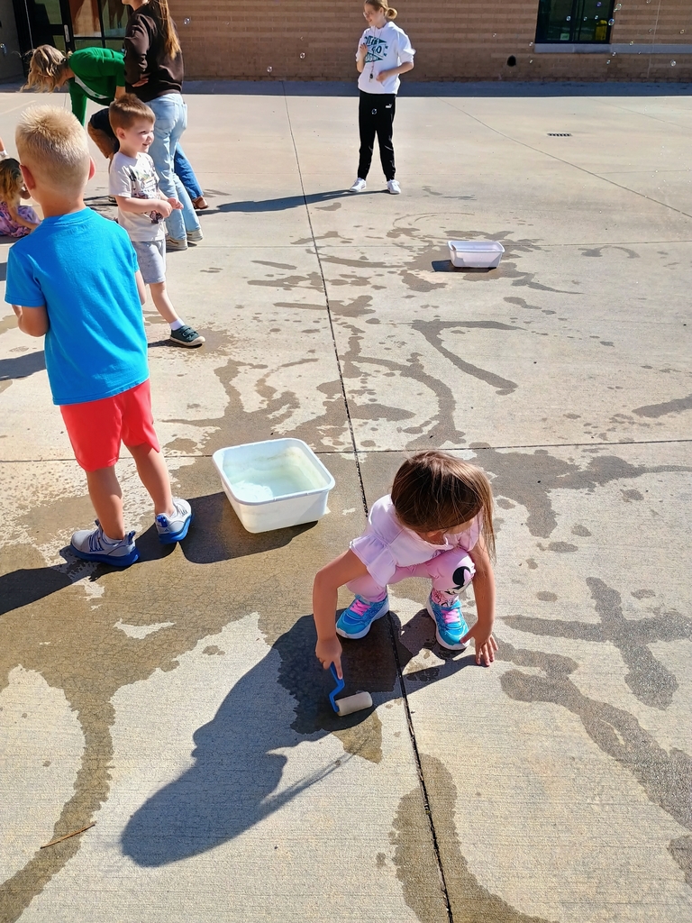 students playing in water on the playground