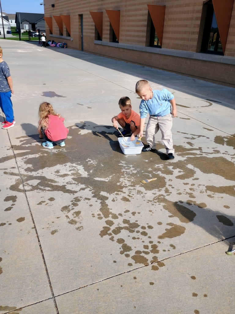 students playing in water on the playground