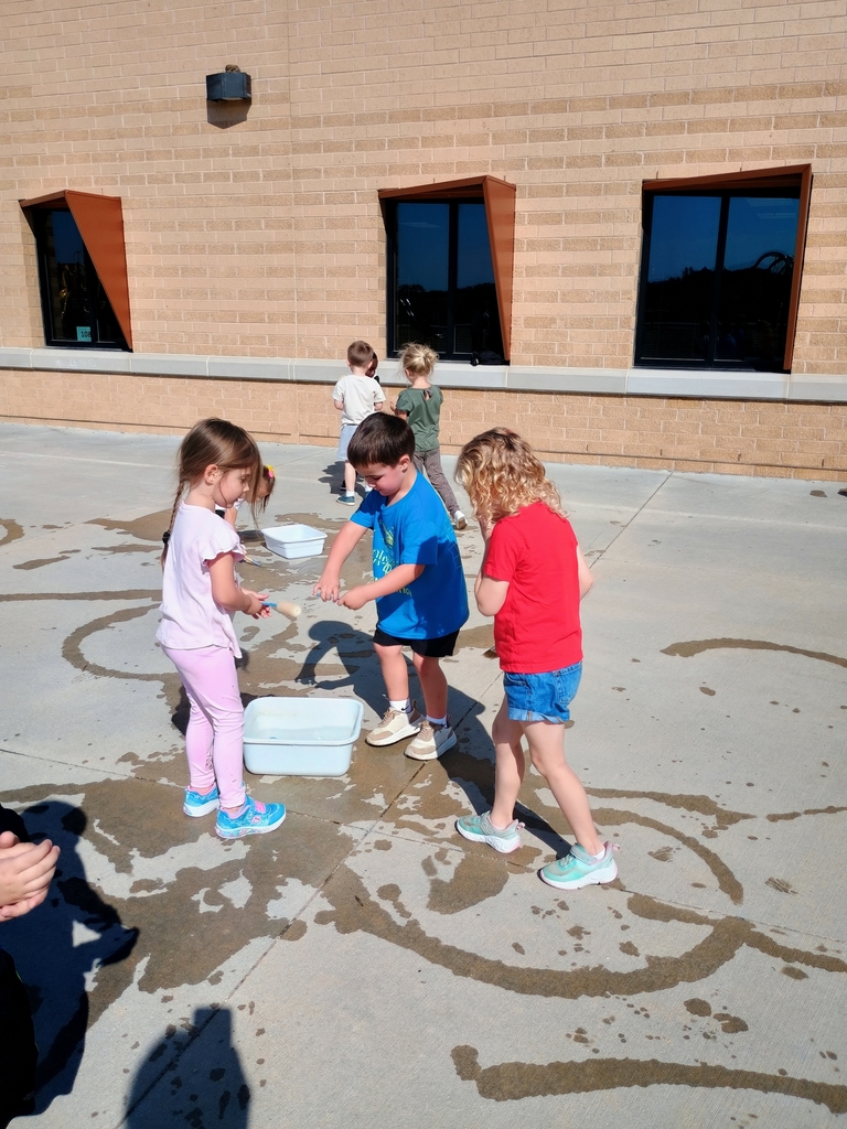 students playing in water on the playground