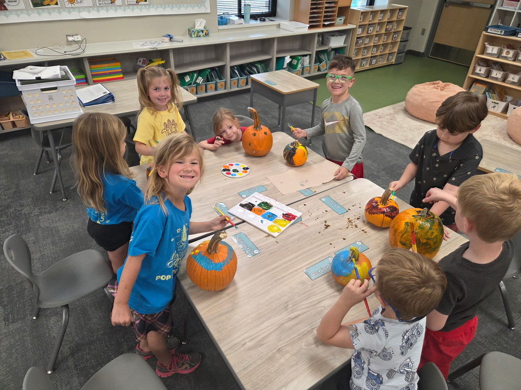 kindergarteners painting pumpkins