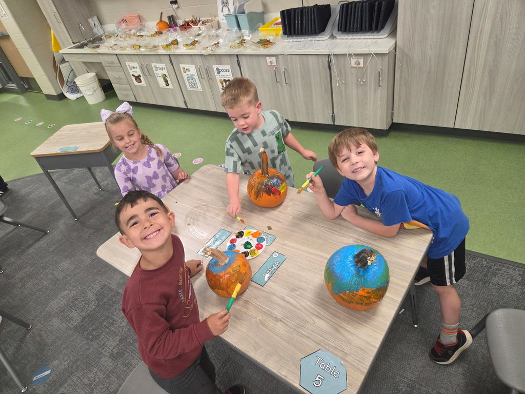 kindergarteners painting pumpkins