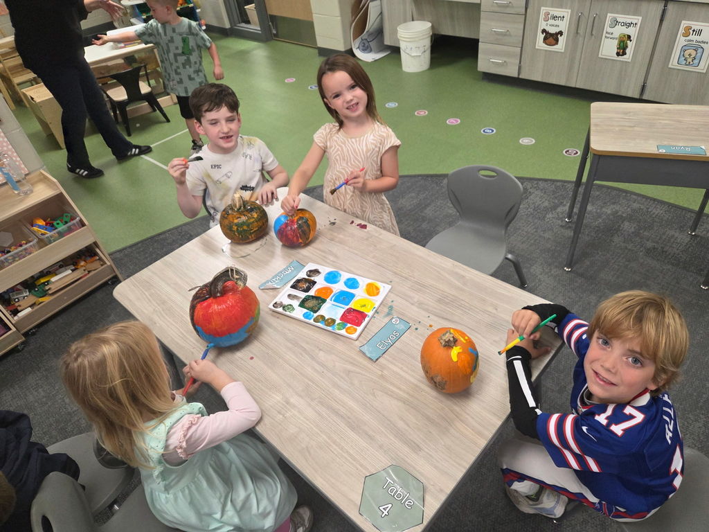 kindergarteners painting pumpkins