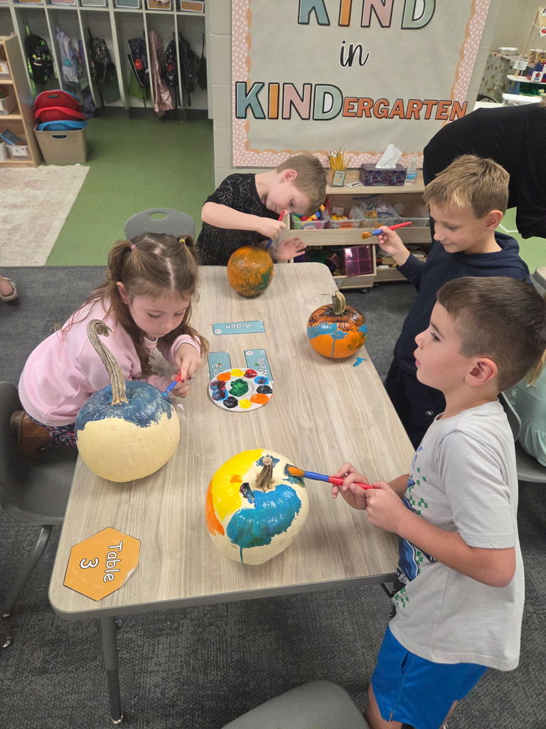 kindergarteners painting pumpkins