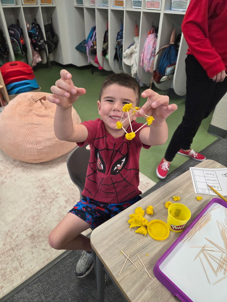 kindergartener working with playdoh and toothpicks