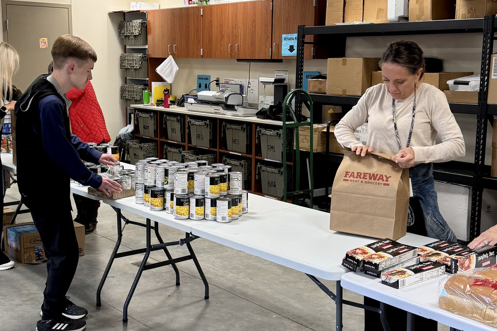 Students from the Young Adult program organizing canned good on the table to be packed to help community families
