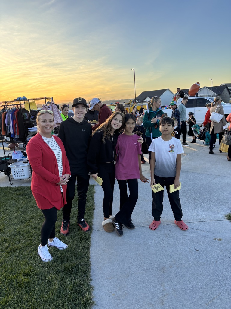 Photo of Ms. Williams and four Kindness Club students standing outside by cars decorated for the Trunk or Treat event.