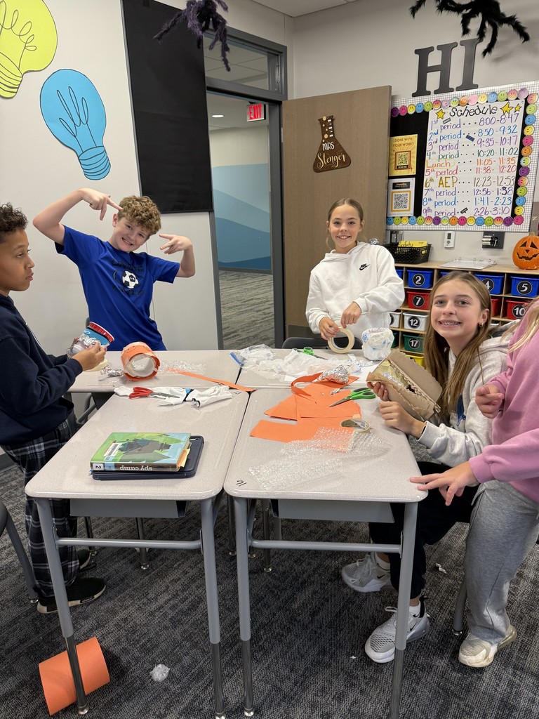 Students at tables working on creating cups. 