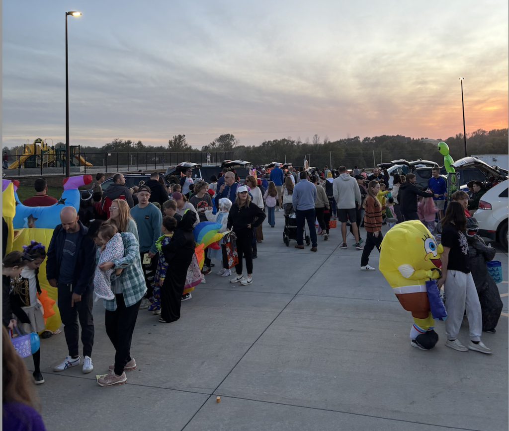photo from the harvest hills trunk or treat. Students in costumes in the parking lot.