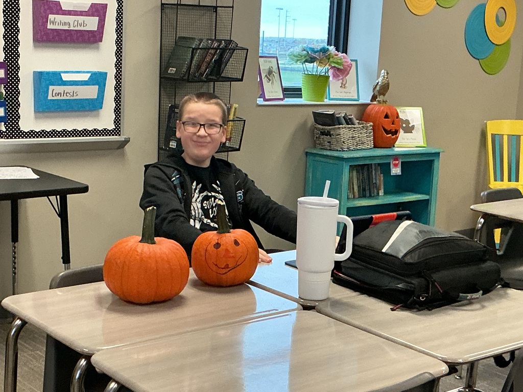 Photo of student posing with his pumpkin.