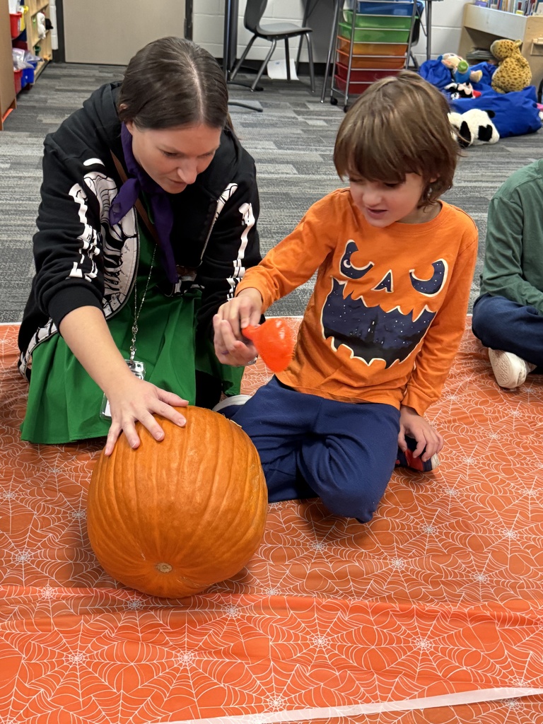 A student and para clean out the pumpkin guts.