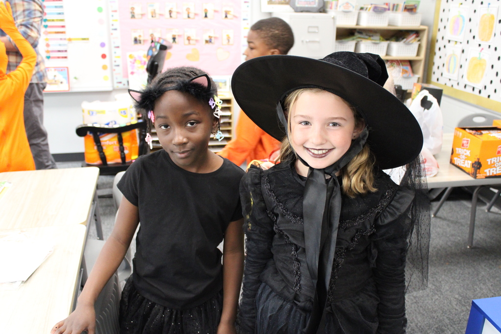 Second grade girls pose for a photo of their costumes together. 