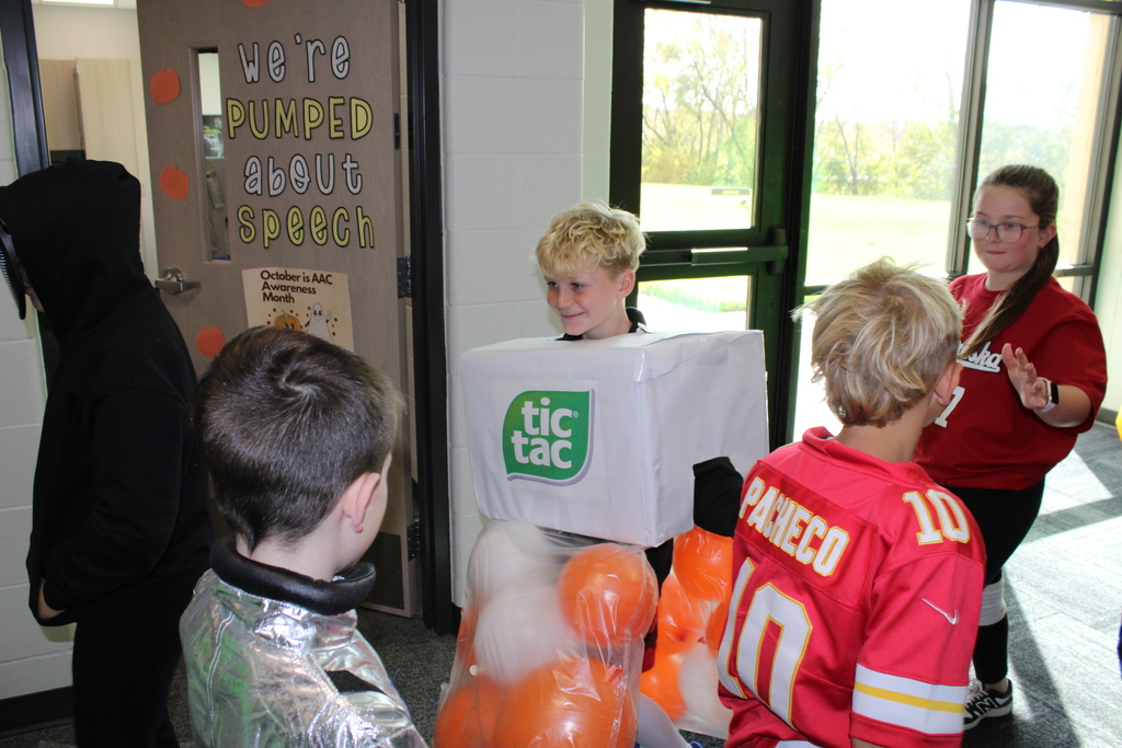 Third grade students high five each other as they pass in the hallway. 