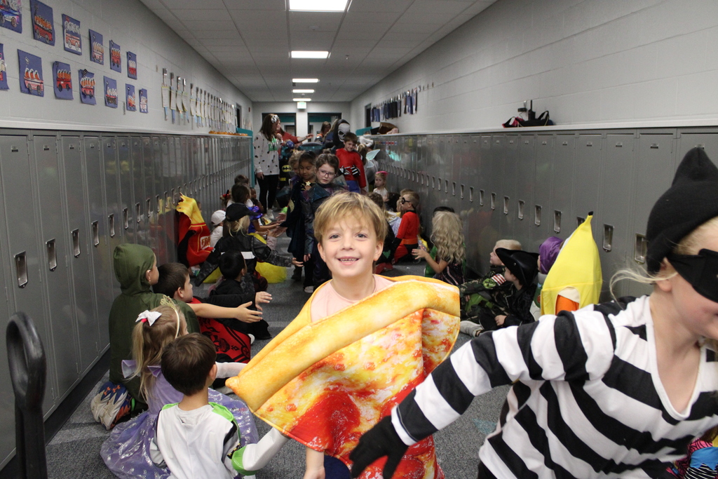 A first grader high fives kindergarteners as he walks in the school parade. 