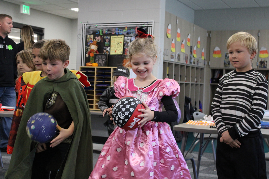 A kindergarten princess gets ready to bowl the ball to knock over toilet paper rolls and win a prize! 