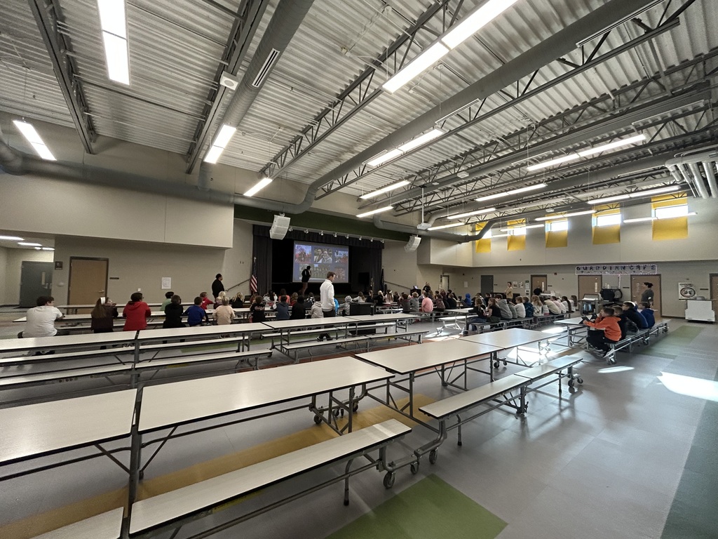 students in the cafeteria at a presentation