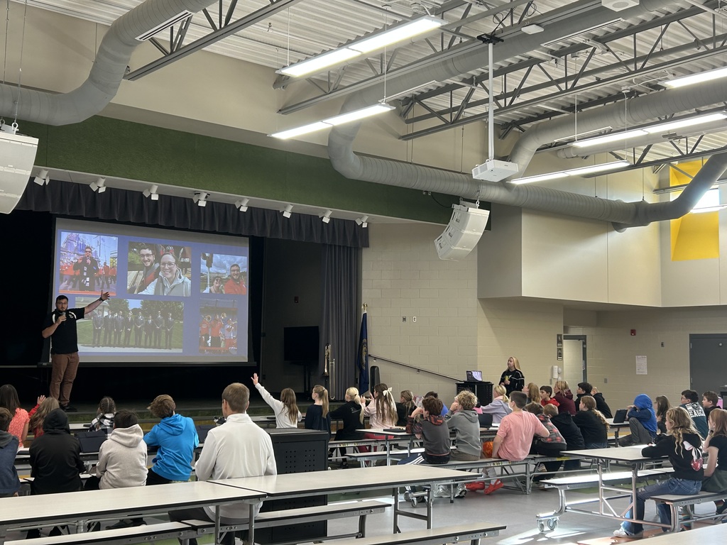 students in the cafeteria at a presentation