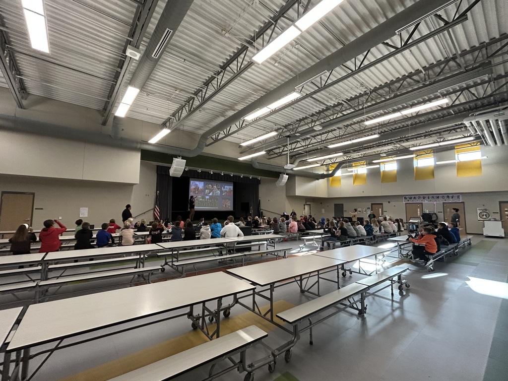 students in the cafeteria at a presentation